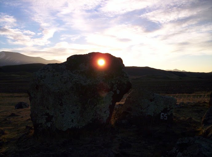Há furos nas rochas. A imagem mostra uma rocha alinhada com o Sol.